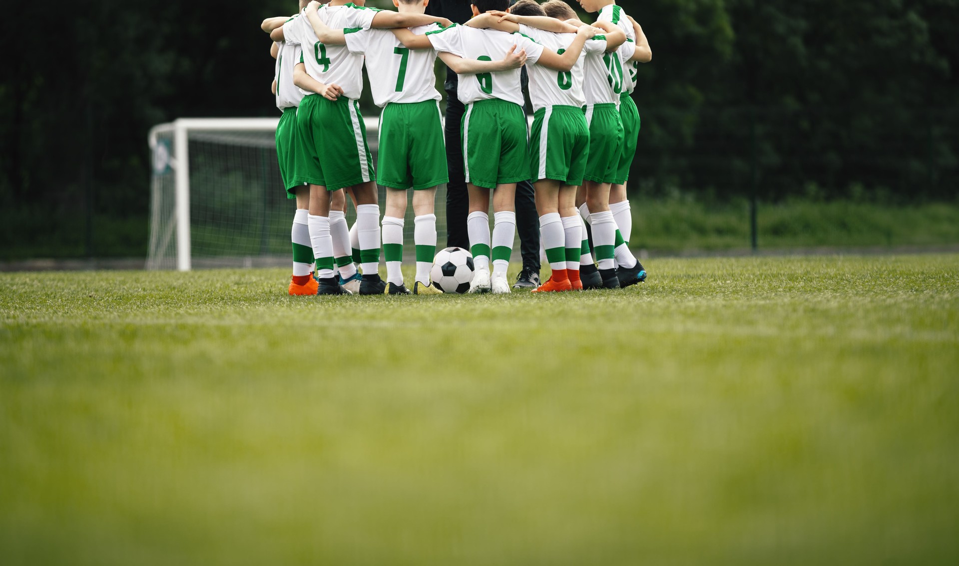 Boys Football Team. Teenage Boys Huddling Together in a Circle on Grass Field. Kids in Sports Team in Building Team Spirit Before The Soccer Game